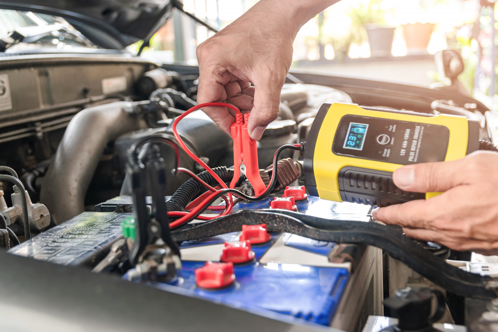 car mechanic is using voltage measuring instrument charging battery